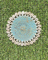 Rattan coaster painted turquoise edged with sea shells.