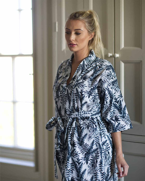 Woman in bedroom in grey leaf printed sleep robe with tie waist.