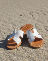 Woman in her fashion accessory, white sliders made from 100% leather. The style is in a H design.
